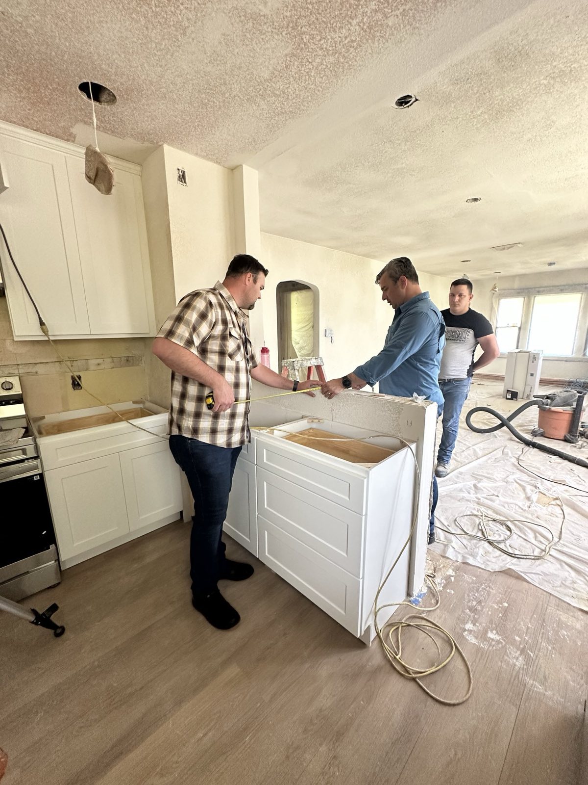Bullock Builders crew installing white shaker cabinets during a kitchen remodel