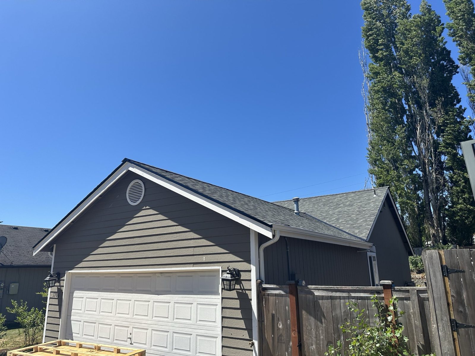 Completed single-story reroof with new architectural shingles on a gray home