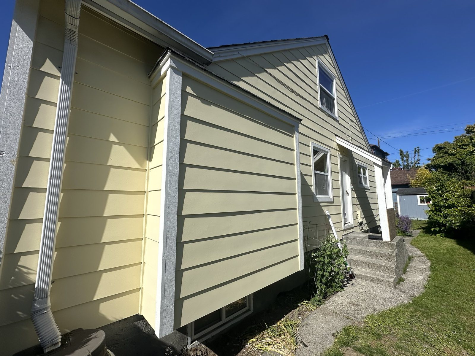 Two-story home with refreshed pale-yellow lap plank siding